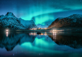 Wall Mural - aurora borealis, snowy mountains, sea, fjord, reflection in water, street lights at starry winter ni