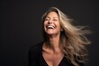 © Igor - Portrait of a happy mature woman laughing with her hair blowing in the wind.