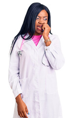 Wall Mural - Young african american woman wearing doctor stethoscope looking stressed and nervous with hands on mouth biting nails. anxiety problem.