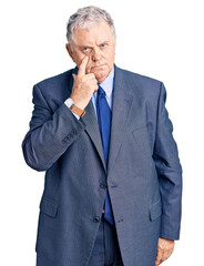 Poster - Senior grey-haired man wearing business jacket pointing to the eye watching you gesture, suspicious expression