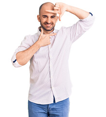 Wall Mural - Young handsome man wearing elegant shirt smiling making frame with hands and fingers with happy face. creativity and photography concept.