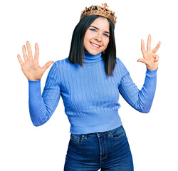 Poster - Young brunette woman with blue eyes wearing princess crown showing and pointing up with fingers number nine while smiling confident and happy.