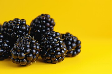 Aufkleber - A pile of blackberries on a vibrant yellow background. Perfect for adding a pop of color to any project