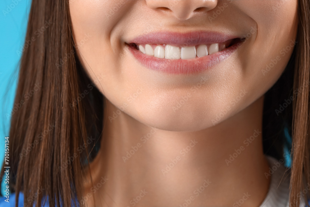 Smiling female dentist on blue background, closeup