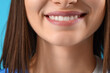 © Pixel-Shot - Smiling female dentist on blue background, closeup