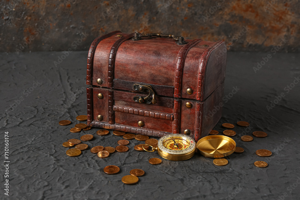 Old chest with treasure and compass on grunge brown background