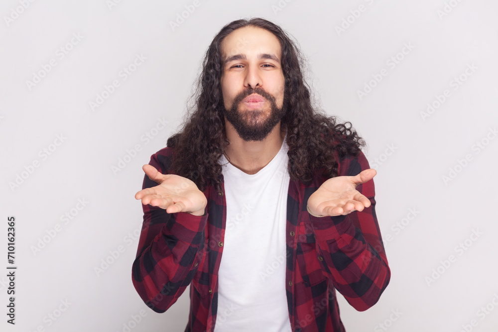 Portrait of pleased bearded man with long curly hair in checkered red ...