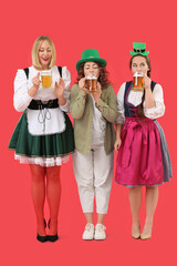 Poster - Portrait of women with beer celebrating St. Patrick's Day on red background