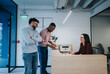 © qunica.com - Professional businesspeople are negotiating a real estate deal. They are discussing and explaining legal documents. A man in pink blouse is signing the contract while colleagues look on and laughing.