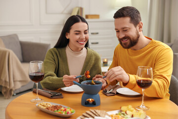 Wall Mural - Affectionate couple enjoying chocolate fondue during romantic date at home