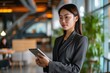© Lumina Frame - Young Asian business woman entrepreneur standing in office holding digital tablet. Businesswoman leader, professional company manager using smart corporate management technology, Generative AI