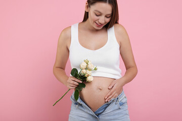 Wall Mural - Beautiful pregnant woman with roses on pink background