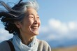 風が吹く空の下で笑顔の日本人シニア女性, Generative AI