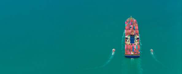 aerial side view of cargo ship carrying container and running for export goods from cargo yard port 