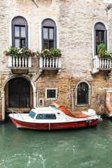 a small watercraft in a canal in venice, italy.