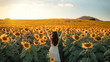 Carefree Happy beautiful young woman in white dress opened arms up in air and looking at sunset in a large field of sunflowers, Freedom concept, Enjoyment, Summer time.