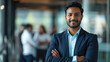 © Farnaces - Portrait of a handsome smiling asian indian businessman boss standing in his modern business company office.