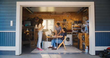 Fototapete - Diverse Team Of Three Young Startup Company Founders Working In Retro Garage, Using Old Desktop Computer. Male And Female Entrepreneurs Developing Innovative Online Service In Nostalgic Nineties.