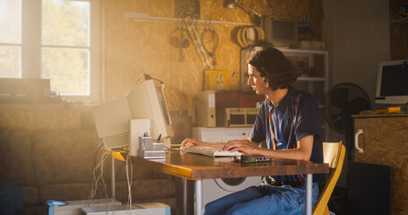Leinwandbilder - Caucasian Male Software Engineer Programming On Old Desktop Computer In Retro Garage With Random Appliances. Man Starting an Innovative Fintech Startup Company In Nineties. Nostalgia Concept.