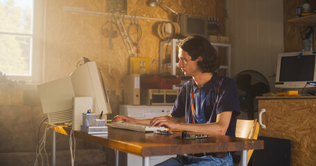 Poster - Caucasian Male Computer Engineer Coding On Old Desktop PC And Inspecting Microchip In Retro Garage. Man Starting an Innovative Computer Company In Nineties, Building New Devices. Nostalgia Concept.
