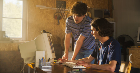 Fototapete - Two Caucasian Male Tech Startup Founders Using Old Desktop Computer In Retro Garage. Software Developer And User Experience Designer Starting New E-commerce Business In nineties. Nostalgia Concept.