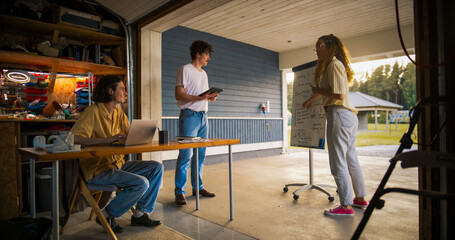 Fototapete - Team Of Young Entrepreneurs Having A Meeting In Home Garage. Hispanic Female Manager Using Whiteboard To Outline Business Plan For Computer Production. Two Male Colleagues Using Laptop And Tablet.