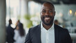 © Farnaces - Portrait of a handsome smiling black businessman boss standing in his modern business company office.