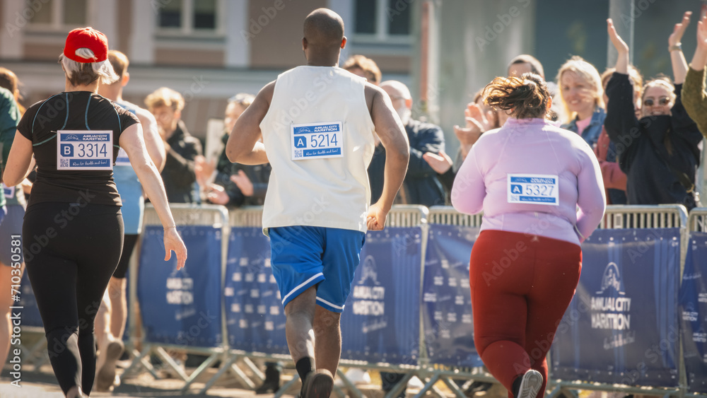 Close Up on the Back of a City Marathon Runners With Signs with Numbers. Diverse Marathon Runners Competing for the First Place in a Race, Waving at their Loved Ones in the Audience