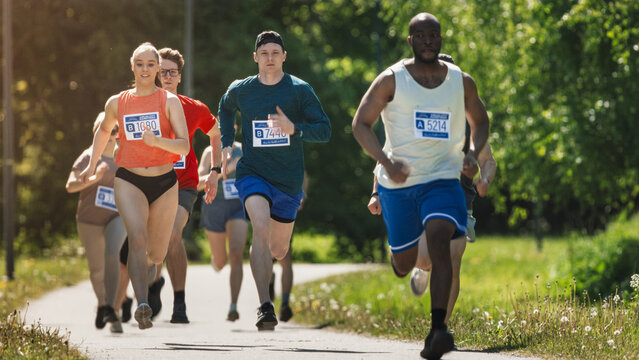 Diverse Marathon Participants Competing in a Race for the Finish Line: Group of People Running Through Park Health Trail and Participating in a Marathon with Dedication