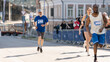 Portrait of a Senior Male Jogger Running in a City Marathon and Being Cheered for by the Audience. Healthy and Fit Elderly Man Enjoying Physical Activity and Staying in Shape