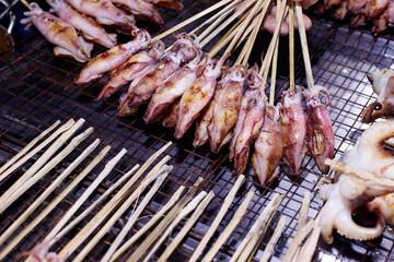 Wall Mural - Street food at crab market. Fresh grilled squid.