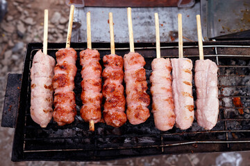 Wall Mural - Street food. Pork sausages on a barbecue. .