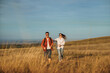 © DusanJelicic - A couple is running on a big golden meadow, wearing sunglasses, smiling and enjoying the sunny autumn day.