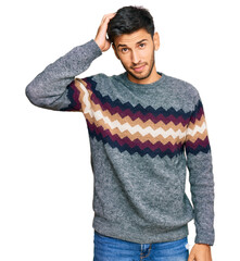 Wall Mural - Young handsome man wearing casual winter sweater confuse and wonder about question. uncertain with doubt, thinking with hand on head. pensive concept.