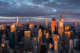 Fototapeta  - Midtown Manhattan supertall skyscrapers illuminated by warm light. Aerial view of New York City at sunset