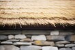 closeup of thatched roof texture with stone walls