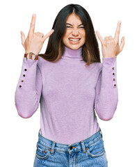 Poster - Young beautiful teen girl wearing turtleneck sweater shouting with crazy expression doing rock symbol with hands up. music star. heavy music concept.