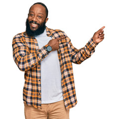 Poster - Young african american man wearing casual clothes smiling and looking at the camera pointing with two hands and fingers to the side.