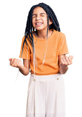 Wall Mural - Cute african american girl wearing casual clothes very happy and excited doing winner gesture with arms raised, smiling and screaming for success. celebration concept.