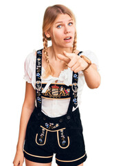 Wall Mural - Young beautiful blonde woman wearing oktoberfest dress pointing displeased and frustrated to the camera, angry and furious with you