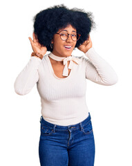 Sticker - Young african american girl wearing casual clothes and glasses trying to hear both hands on ear gesture, curious for gossip. hearing problem, deaf