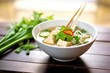 pho with tofu and veggies, focused on green onion garnish