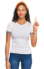 Poster - Young african american girl wearing casual clothes showing and pointing up with finger number one while smiling confident and happy.