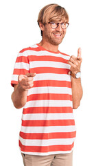 Poster - Handsome caucasian man with beard wearing casual clothes and glasses pointing fingers to camera with happy and funny face. good energy and vibes.