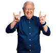 © Krakenimages.com - Senior man with grey hair wearing casual shirt and glasses shouting with crazy expression doing rock symbol with hands up. music star. heavy concept.