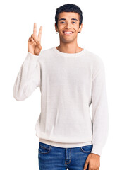 Canvas Print - Young african amercian man wearing casual clothes showing and pointing up with fingers number two while smiling confident and happy.