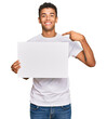 © Krakenimages.com - Young handsome african american man holding blank empty banner pointing finger to one self smiling happy and proud