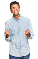 Sticker - Young handsome african american man wearing casual clothes very happy and excited doing winner gesture with arms raised, smiling and screaming for success. celebration concept.