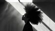 Photo of a African woman with a Dramatic, Asymmetrical Hair Style, standing out in a minimalist, brightly lit space