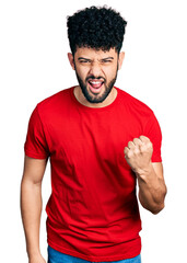 Sticker - Young arab man with beard wearing casual red t shirt angry and mad raising fist frustrated and furious while shouting with anger. rage and aggressive concept.